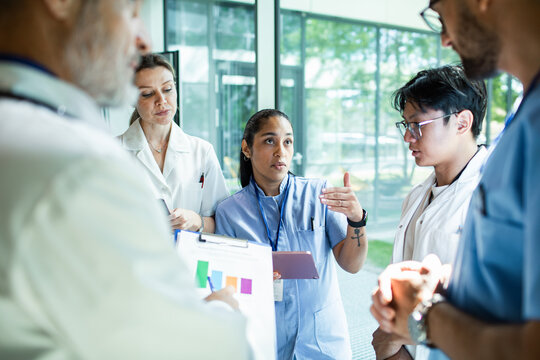 Doctors and nurses discussing patient care in hospital corridor