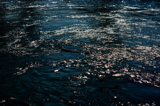 Sparkling surface of deep blue flowing water