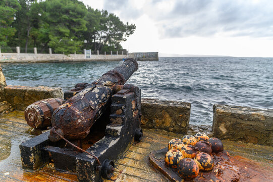 Corroded cannon and cannonballs by the sea near Ježinac Beach, Split, Croatia