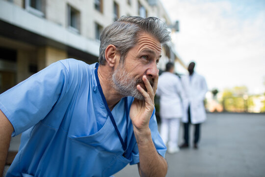 Stressed healthcare worker outside hospital