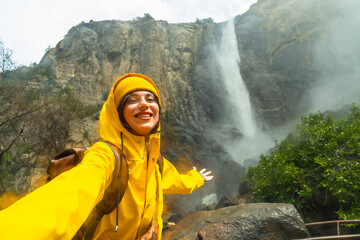 Obraz premium Woman enjoying misty bridalveil fall selfie in yosemite