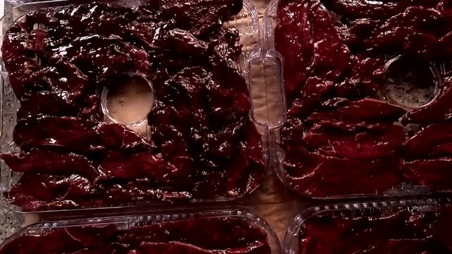 Detailed view of cacao or chocolate mixture filling plastic molds, with glossy texture, handmade food process and tropical ingredient scene, suitable for stock footage about travel, nature, lifestyle