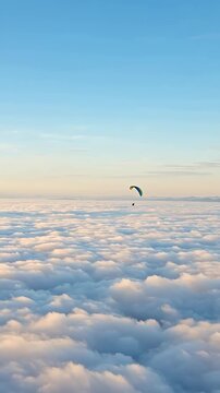 Paraglider Soaring Above a Sea of Clouds at Dawn
