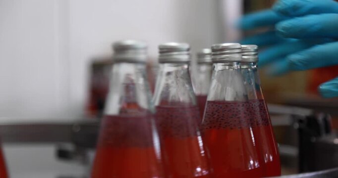 At beverage bottles line, focused workers systematically organizes the bottles into a large container. then staged at the loading dock, ready for distribution in beverage drinking water factory