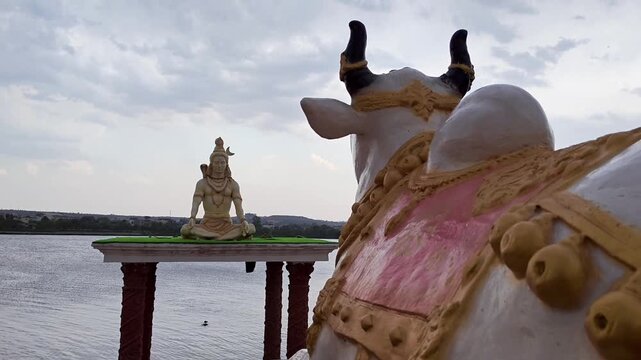 Closeup of lord shiva statue with flowing river background