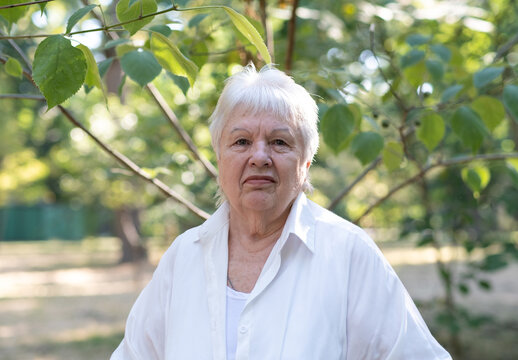 Portrait of smiling senior woman in city park looking at camera