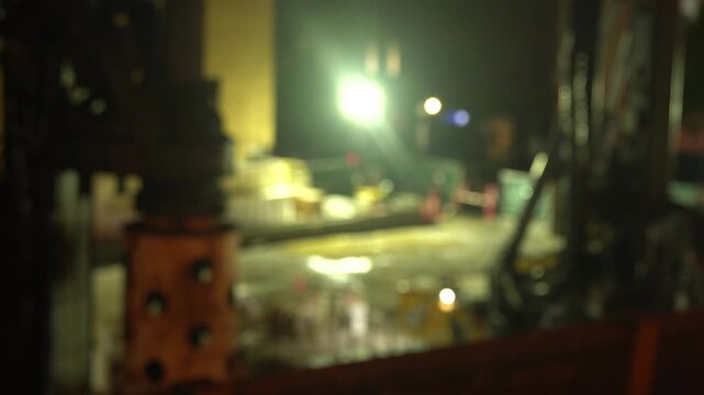 A cinematic nighttime video clip of an industrial drilling machine at a construction site.
