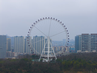 Ferris wheel in Guanshanhu District, Guiyang skyline on a hazy spring day © HoangVan