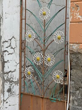 Decorative door with flower design in an urban setting during the day