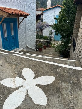 Charming steps lead to colorful houses in a small village with flower designs on the path