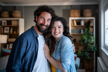 Fototapeta premium Happy adult couple smiling and embracing at home