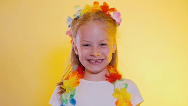 Slow Motion Close Up Joyful Little Girl In Hawaiian Outfit With Strong Wind Blowing Off Flower Crown On Yellow Background