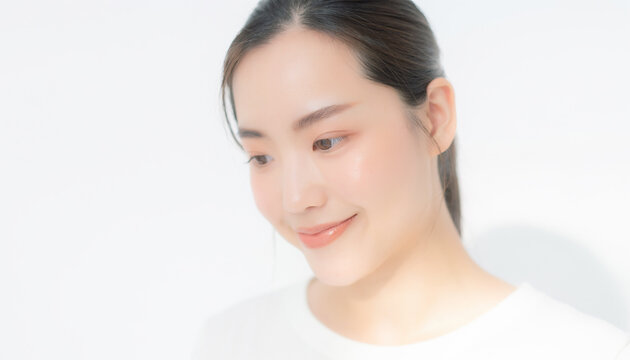 Beautiful Asian woman looking down and smiling with glowing skin for beauty care　白背景で優しい微笑みを浮かべるアジア人女性のポートレート 伏し目 美容 スキンケア