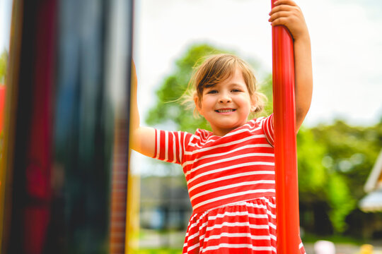 Happy child girl on playground on summer season