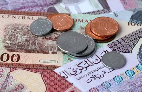 Omani rial money banknotes and coins on table. Oman cash bills of OMR currency close up