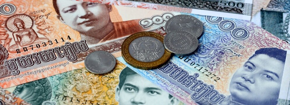 Cambodian riel money banknotes and coins on table. Cambodia cash bills of KHR currency