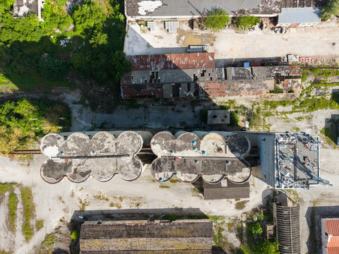 Aerial view of an industrial grain silo complex with weathered concrete structures and surrounding warehouses in Balchik, Dobrich Province, Bulgaria.