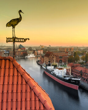Aerial view of the Motlawa River and the SS Soldek museum ship docked near historic brick buildings at sunset Gdansk, Pomeranian Voivodeship, Poland.