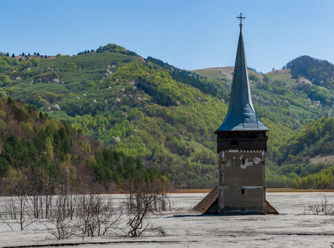 Church tower rising from the toxic tailings lake of Geamana, flooded by mining waste from Roșia Poieni copper mine, Apuseni Mountains, Romania. 