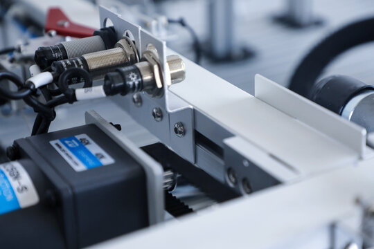 Industrial automation machine with proximity sensors and conveyor mechanism