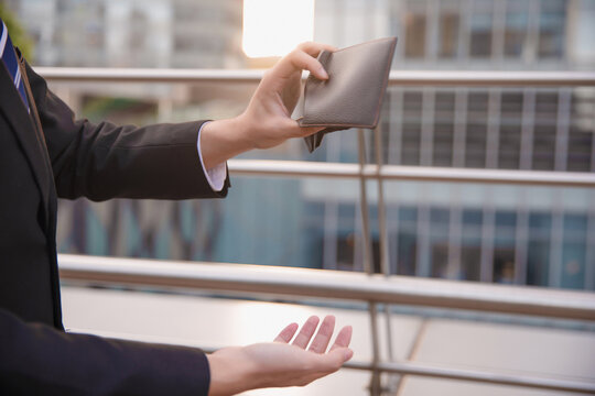 Businessman Holding Empty Wallet in City Financial Crisis Concept