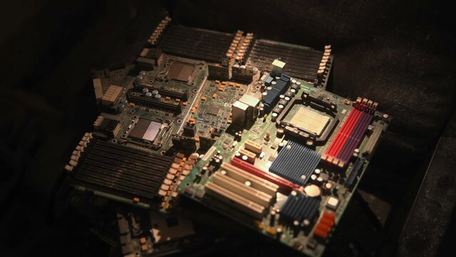 Closeup Of Computer Mainboard Details. Detailed Shot Of Motherboard Components Illuminated By Spotlight. Media