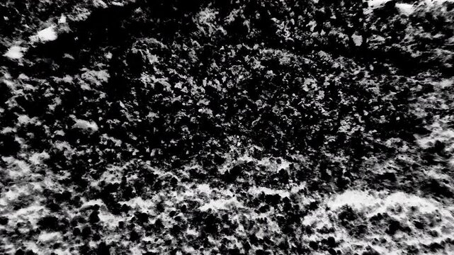 Grunge stone texture with dark bacground and white spots overlaying it.