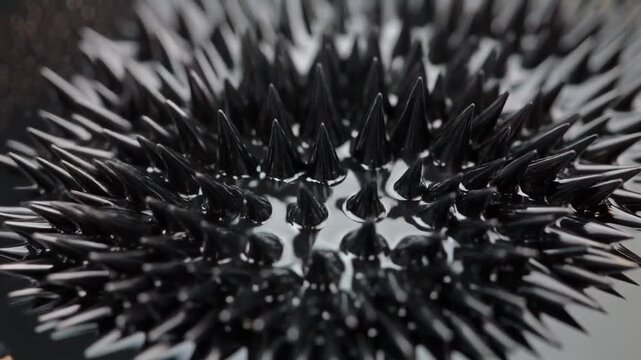 Close-up of black plastic spikes arranged in a grid pattern. Sharp pointed objects. Static detailed view of industrial or decorative elements.
