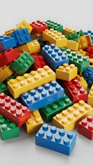 Naklejka premium Colorful LEGO Building Blocks in Various Shapes and Sizes Spilled Over White Surface