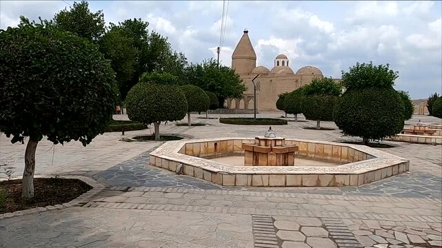 Panning shot of Chashma Ayub Mausoleum and empty fountain square