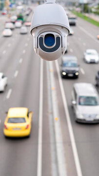 Traffic surveillance camera monitors vehicle movement on busy highway during day