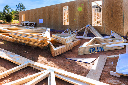 Wooden beams panels are arranged on ground near walls of building under construction