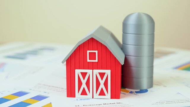 Farm barn on documents and reports. Farming and agribusiness business concept. Sustainable agriculture, rural economy, food production. Investments in farming technology.