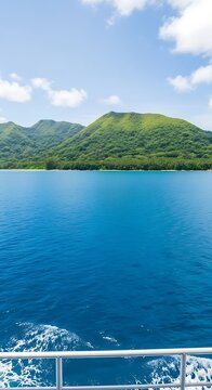 Vibrant blue ocean churns behind a boat, leading to lush green islands