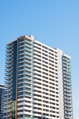 Fototapeta premium Modern high-rise residential buildings with beautiful new facades against a clear blue sky.
