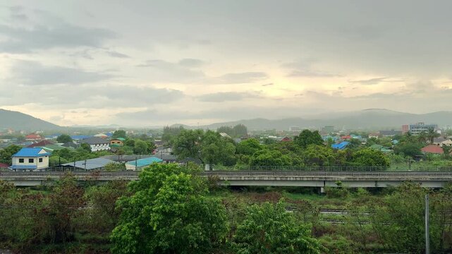 4K Timelapse of overcast sky and moody clouds moving over mountains and town in Hua Hin, Thailand.