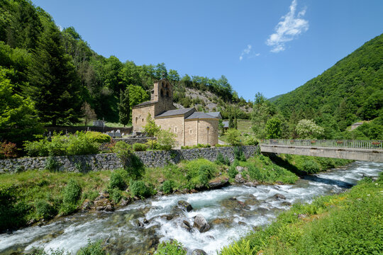 Mountain landscape with a 12th century Romanesque church and a river in the foreground. Salau Ariege Pyrenees France