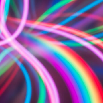 Vibrant, blurred neon light trails form abstract, colorful swirls