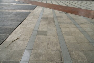 Outdoor paving with textured stone tiles and brick border © Arsy