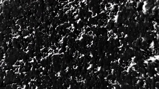 Grunge stone texture with dark bacground and white spots overlaying it, 4K stop motion video.