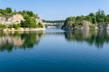 Fototapeta premium Zakrzowek quarry lake in Krakow with deep blue water and rocky cliffs, Poland
