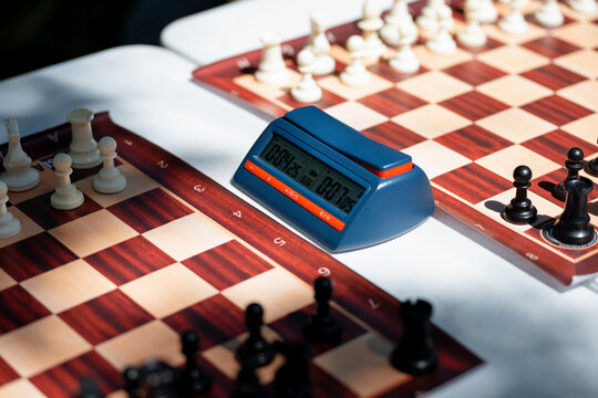 Digital chess clock timer close up on a wooden chessboard background during a match