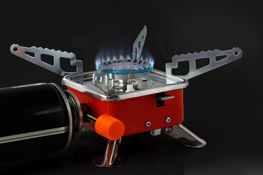 Working camping gas stove isolated on black background. Tourist gas stove.