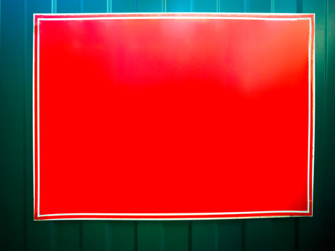 Blank empty red banner on green fence background