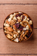 Fototapeta premium A mix of pistachios, hazelnuts, walnuts, peanuts, dried berries, and fruits. A mix of nuts