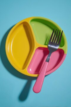 Sustainable sectioned plate in pastel colors with practical divisions and fork, transforming mealtime into joyful learning.