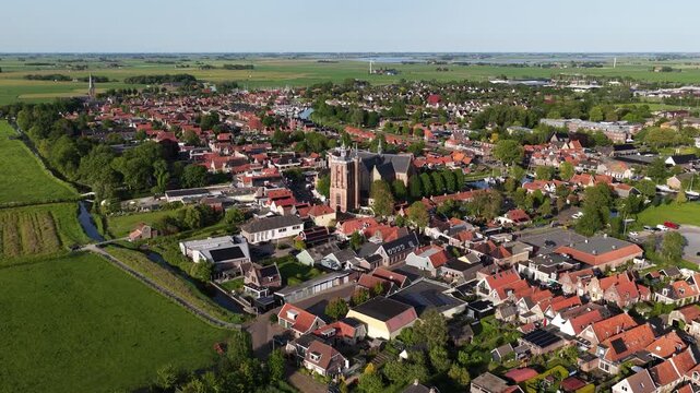 Aerial view of the historic town of Workum featuring the central church surrounded by traditional red-tiled roofs and green fields Workum, Friesland, Netherlands.