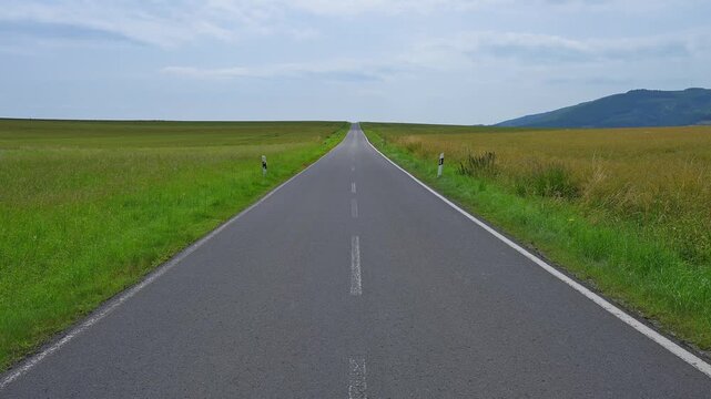 Eine gerade Landstra&szlig;e f&uuml;hrt durch weite Felder zu fernen H&uuml;geln unter einem bew&ouml;lkten Himmel, Orferode, Stadt Bad Sooden-Allendorf, Werra-Mei&szlig;ner-Kreis, Hessen, Deutschland