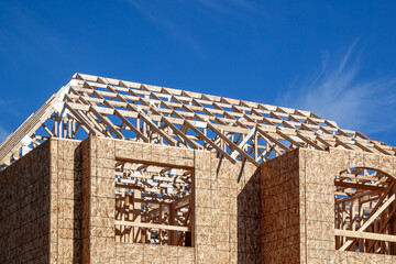Naklejka premium The new house wood framing under construction against the blue sky. Toronto, Ontario, Canada. 