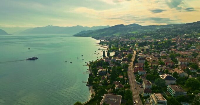 Establishing shot of swiss city Lausanne in summer day. Aerial view of the Switzerland city on the shores of Lake Geneva